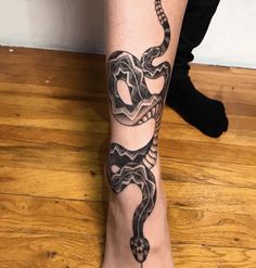 a woman's foot with a tattoo on it and a snake crawling around the ankle