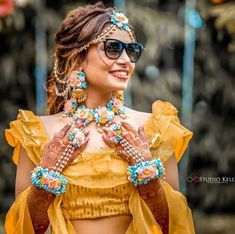 a woman in a yellow top and sunglasses