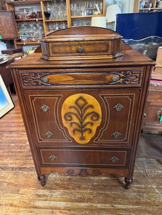 an old fashioned wooden cabinet with ornate carvings on the front and sides, sitting on a hard wood floor