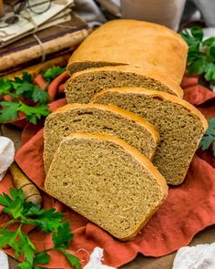 sliced loaf of bread sitting on top of a red napkin next to some parsley