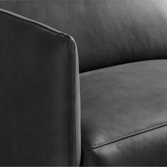 a black and white photo of a couch with leather upholstered on the back