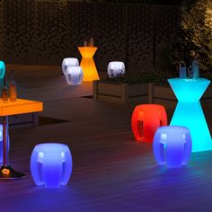 several illuminated stools and tables on a deck