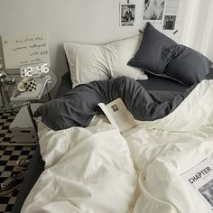 an unmade bed with black and white checkered flooring