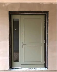 a green door is open on a beige wall