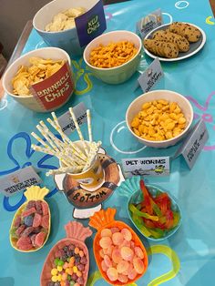 a table topped with bowls filled with different types of snacks