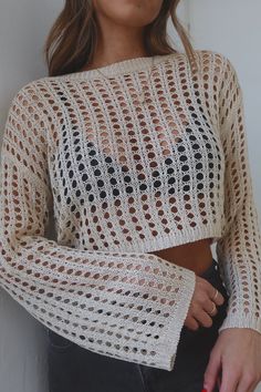 a woman wearing a white knitted sweater with black dots on the chest and sleeves