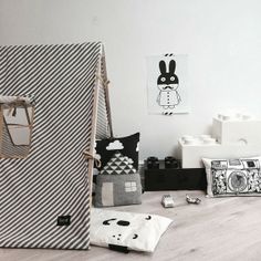 the interior of a white room with black and white accessories on the floor, including an open refrigerator