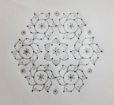 a circular design made out of glass beads on a white tablecloth with blue dots