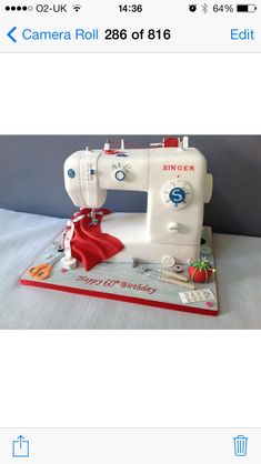 a white sewing machine sitting on top of a table next to a red and white object