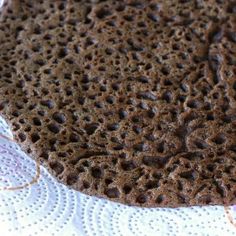 a piece of chocolate cake sitting on top of a white doily covered table cloth