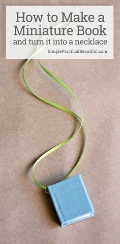 a blue book sitting on top of a table next to a green ribbon and the title how to make a miniature book and turn it into a necklace