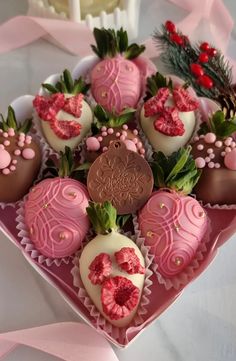 a pink heart shaped box filled with chocolate covered strawberries and topped with strawberrys