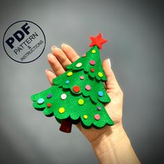 a hand holding up a green felt christmas tree