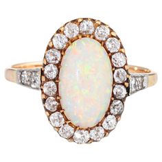 Elegant antique Victorian opal & diamond ring (circa 1880s to 1900s) crafted in 9 karat yellow gold. Natural opal measures 11mm x 7mm (estimated at 1.50 carats). 22 old mine cut diamonds total an estimated 1 carat (estimated at J-K color and SI1-I1 clarity). The opal is in very good condition and free of cracks or chips (some light surface abrasions from wear over the years). The natural opal exhibits a strong color matrix with flashes of green, orange, yellow, purple and blue (the photos don't Luxury Oval Opal Ring In Art Deco Style, Luxury Oval Art Deco Opal Ring, Sapphire Cocktail Ring, Opal Diamond Ring, Vintage Fine Jewelry, Right Hand Rings, Victorian Rings, Diamond Cocktail Rings, Alternative Engagement Rings