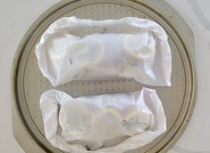 two rolls are wrapped in white paper on a frying pan, ready to be cooked