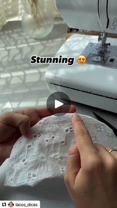 someone is using a sewing machine to sew something on the paper towel that they are holding in their hands