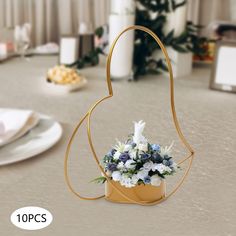 a vase filled with flowers sitting on top of a table next to plates and utensils