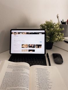 an open book sitting on top of a laptop computer next to a mouse and keyboard