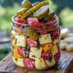 a jar filled with pickles and cheese on top of a wooden table