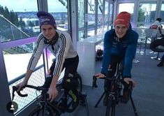 two people riding bikes in an indoor area