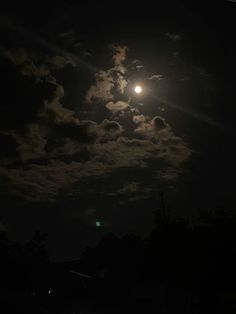 the full moon shines brightly in the dark sky above some houses and trees at night