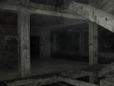 an abandoned building with graffiti on the walls and flooring in dark, foggy conditions