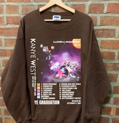 Kanye SweatShirt, Late Registration sweatshirt, West Tour 2023 tshirt, Kanye Graphic tshirt, gift for men women Comfort Color ABOUT MATERIAL: Comfort Colors® 1717 Made with medium fabric (6.1 oz/yd² (206.8 g/m consiting of high quality, 100% ring-spun US cotton for long-lasting comfort. The relaxed fit keeps the wearer comfy in both casual and semi-formal settings while the crew neckline delivers that classic, neat style which makes it perfect for accessorizing. What's more, the pre-shrunk fabri Band Merch Crew T-shirt For Winter, Winter Graphic Print Short Sleeve Sweatshirt, Cotton Sweatshirt With Custom Print For Streetwear, Relaxed Fit Graphic Tee Sweatshirt For Fans, Short Sleeve Sweatshirt For Fall Streetwear, Winter Band Merch Crew T-shirt, Winter Band Merch T-shirt With Crew Neck, Streetwear Custom Print Crew Top, Cotton Band Merch Short Sleeve Sweatshirt