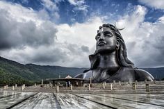 there is a large statue in front of the mountains