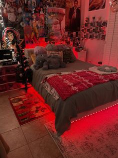 a bed with red lights on it in a room filled with posters and pictures above the bed