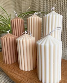 four candles sitting on top of a wooden shelf