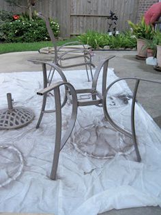 two chairs sitting on top of a table covered in white cloth next to a potted plant