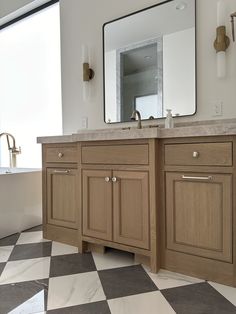 a bathroom with a checkered floor and large mirror