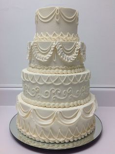 a three tiered wedding cake with white frosting