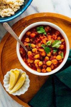 a bowl of chickpeas and rice on a wooden platter