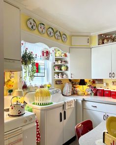 a kitchen with white cabinets and yellow walls