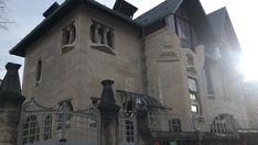 a large building with lots of windows next to a fence