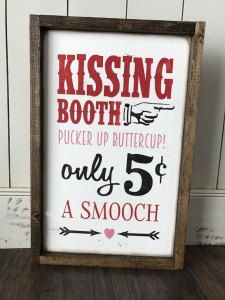 a sign that says kissing booth pucker up buttercup only 5 cents a smooch