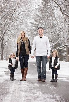 a man, woman and two children walking in the snow