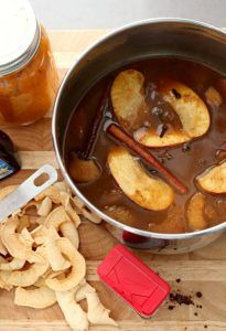 a pot filled with food next to a knife and some chips on a cutting board