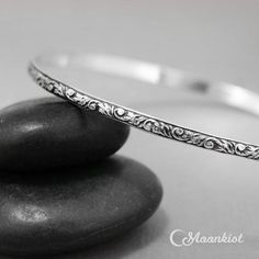 This Floral Sterling Silver Bangle Bracelet measures 3 mm wide (about .11") and features a lovely stylized tendril and vine motif. The inside is gently curved for comfortable wear, and has been antiqued and then repolished to show the delicate details of the patterning. I also offer a brightly polished finish, if you prefer. This bracelet can be made in any size you need and makes lovely wedding jewelry, commitment jewelry, or promise jewelry.Bangle Sizes:●Extra Small - 2 1/4" diameter, approx. Adjustable Bohemian Bangle For Anniversary, Adjustable Round Etched Bracelets, Adjustable Etched Round Bracelets, Adjustable Bracelets With Intricate Design, Adjustable Etched Bracelets, Adjustable Round Bangle With Intricate Design, Delicate Adjustable Round Bangle, Elegant Adjustable Engraved Bangle, Etched Round Bracelet As Gift