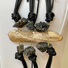 Designed and handcrafted by Greek designer Katerina Vassou. The materials are combined vigorously, without looking busy, just cleverly imposing their presence. Synthetic leather cord. Black agate stone. Luxury Handmade Adjustable Necklace, Elegant Hand Wrapped Leather Jewelry, Handmade Leather Lariat Jewelry, Luxury Adjustable Necklace With Natural Stones, Artisan Necklace With Large Adjustable Stone, Unique Adjustable Necklace With Large Stone, Elegant Adjustable Necklace With Raw Stone, Adjustable Unique Onyx Necklaces, Unique Black Leather Jewelry