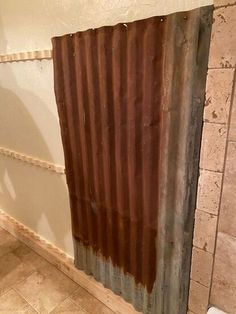 a bathroom that is being remodeled with tile on the floor and rusted metal curtain