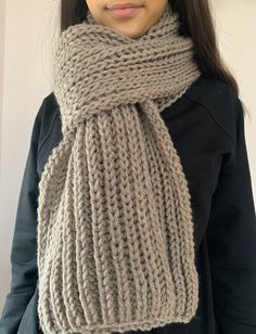 a woman is wearing a knitted scarf