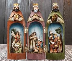 three nativity figurines are sitting on a wooden table next to each other