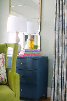 a green chair sitting in front of a blue dresser