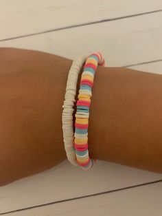 a woman's arm with two different colored bracelets on top of each other