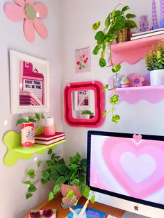 a desktop computer sitting on top of a wooden desk next to a potted plant