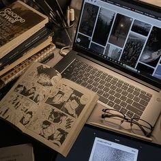 an open laptop computer sitting on top of a desk next to books and other items