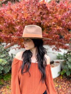 a woman wearing an orange top and hat