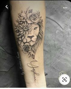 a woman's leg with flowers and a lion tattoo on the side of her arm